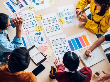 Top-View auf ux Entwickler und ui Designer Brainstorming über mobile App-Schnittstelle