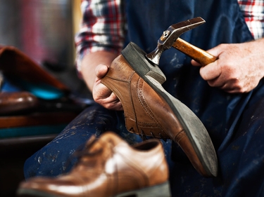 Ein Mann repariert Schuh