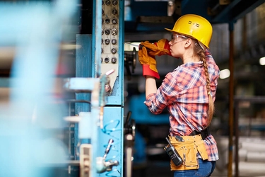 Junge Technikerin in einer Fabrik