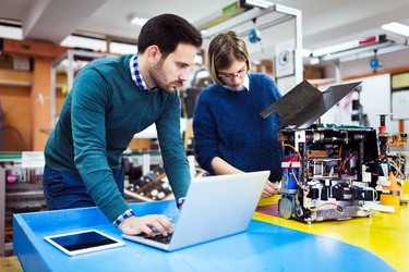 Mann und Frau prüfen die Technik einer neuen Maschine