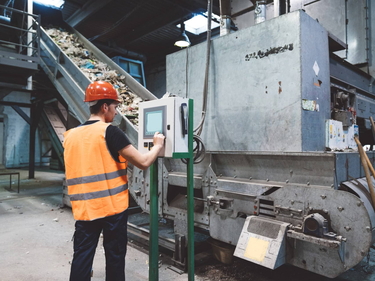 Person arbeitet in einer Müllverbrennungsanlage