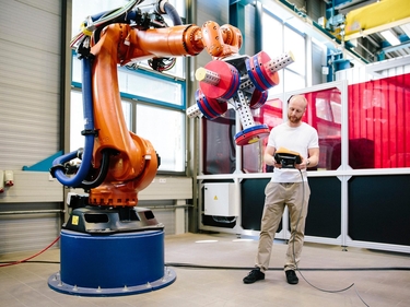 Industrie 4.0: Junger Ingenieur arbeitet an einem Roboterarm