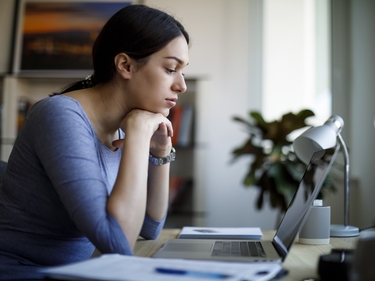 Junge Frau sitzt an ihrem Schreibtisch im Home Office