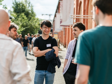 Junger Mitarbeiter spricht mit Kollegen
