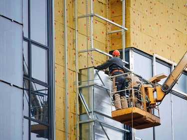 Bauarbeiter dämmen ein Haus