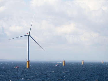 Offshore-Windräder vor bewölktem Himmel