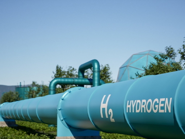 Blaue Wasserstoff-Pipeline im Freien mit „HYDROGEN“-Aufschrift und H2-Logo.