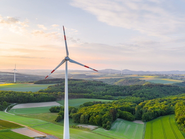 Windrad im Dunst auf einem Feld