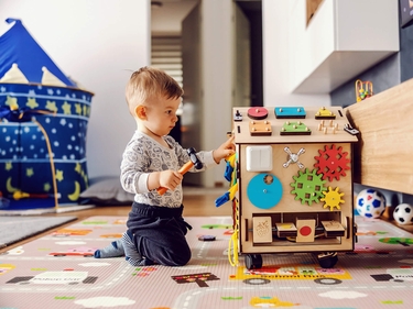 Junge im Kindergartenalter spielt mit Holzspielzeug