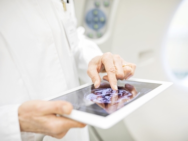 Arzt oder Forscher in einem weißen Kittel, der ein Tablet in den Händen hält