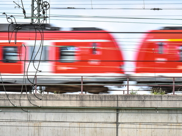 Ein unscharfes Bild einer fahrenden roten Regionalbahn in Nahaufnahme.