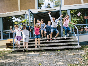 Schulkinder laufen von der Schule zum Schulhof