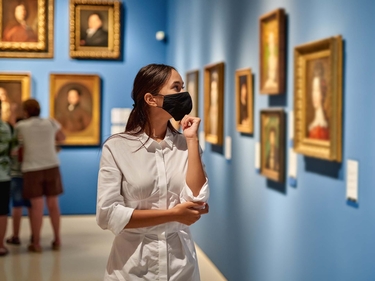 Frau mit Mund-Nasen-Schutz im Museum