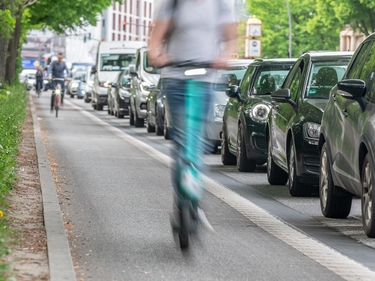 Radweg auf dem vorne ein E-Roller und weiter hinten ein Fahrrad fahren