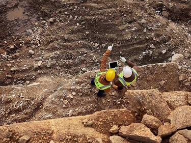 Zwei Industriearbeiter begutachten eine Bergbaustelle