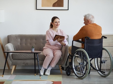 Pflegerin spricht mit einem Patienten