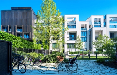 Fahrräder abgestellt vor neugebauten Apartement-Wohnhäusern
