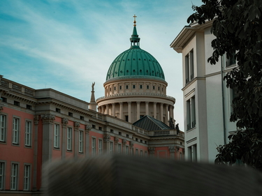 Kuppel der St. Nikolai Kirche Potsdam hinter rotem Gebäude