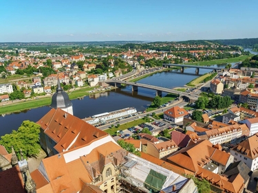 Ein Fluss fließt durch eine Stadt, zwei Brücken führen über den Fluss