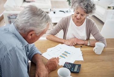 zwei Senioren sehen sich die Auswertung ihrer Finanzinvestitionen an