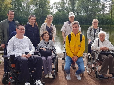 Prognos Mitarbeiterinnen und Mitarbeiter mit Bewohnern und Bewohnerinnen eines Pflegeheimes im Park