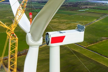 Luftaufnahme einer Windkraftanlage bei der Installationvder Rotorblätter