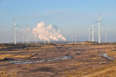 Windkrafträder stehen auf einem kahlen Feld