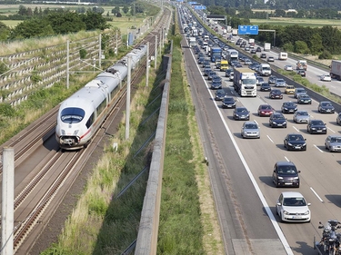 Stau auf der Autobahn und fahrender Zug