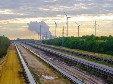 Schienen im Vordergrund, Windräder im Hintergrund