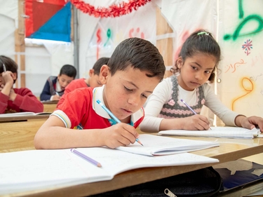 Kinder beim Unterricht in einer Zeltschule 