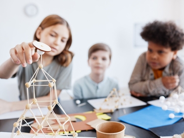Teenager-Kinder, die im Kunst- und Handwerksunterrichts in der Schule Holzmodelle herstellen
