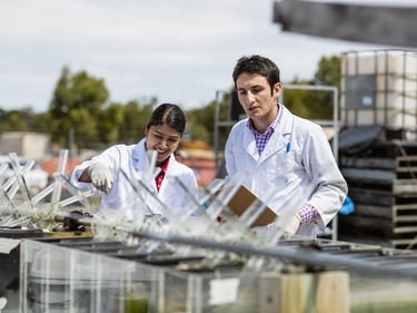 Zwei Wissenschaftler arbeiten draußen an einem Experiment