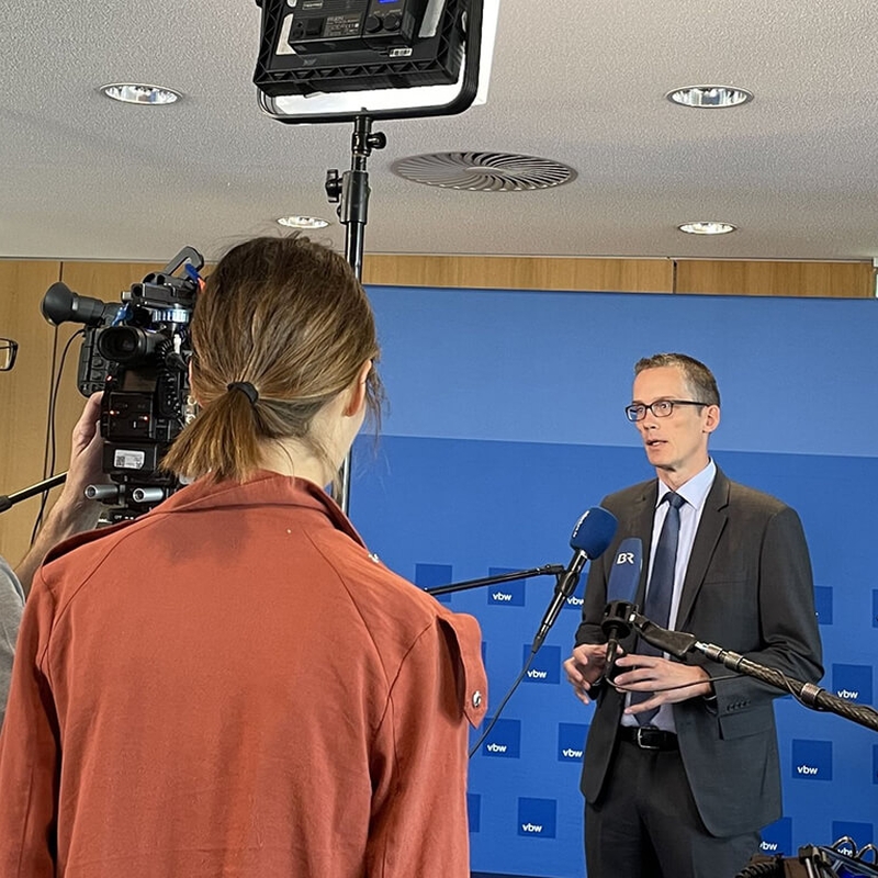 Michael Böhmer im Interview, drei Leute stehen mit Kamera, Beleuchtung und Mikrofonen vor ihm