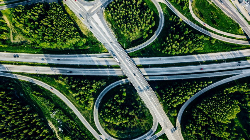 Luftaufnahme von Autobahn und Überführung mit grünen Wäldern