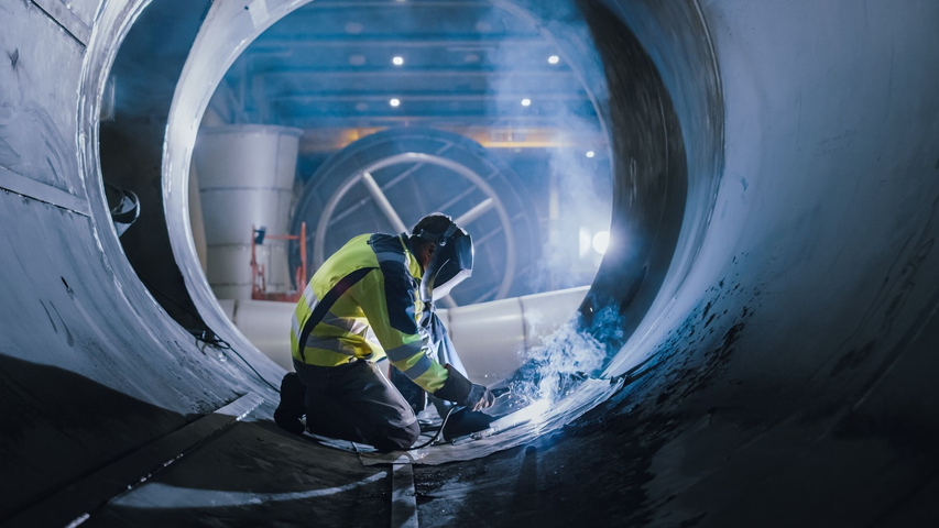 Aufnahme eines Arbeiter, der Schweißarbeiten in einem großen Rohr macht