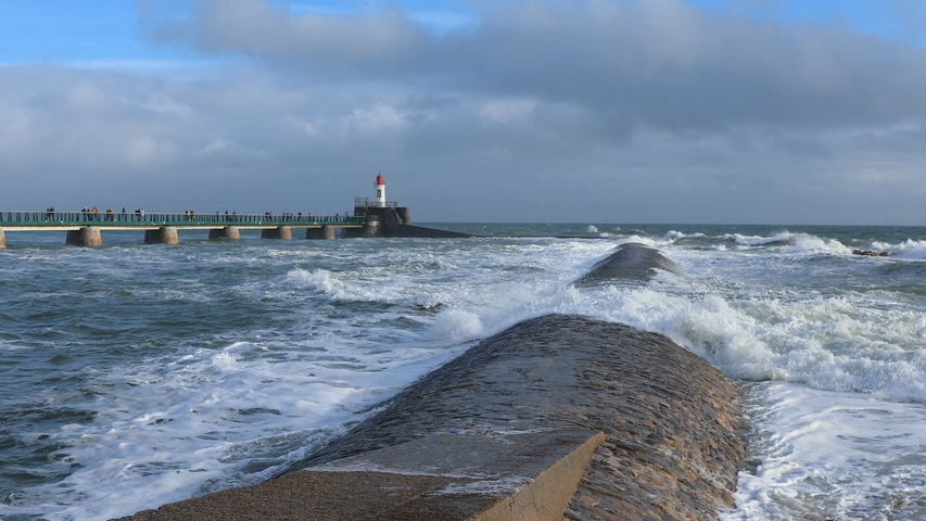 Stürmische See, im Hintergrund eine Seebrücke und ein Leuchtturm