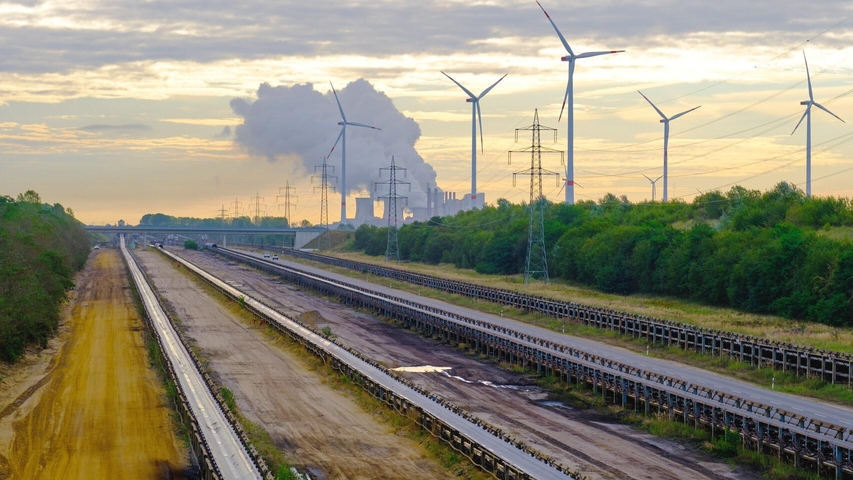 Autobahnen, im Hintergrund Stromleitungen, Windkraftanlagen und Industrie