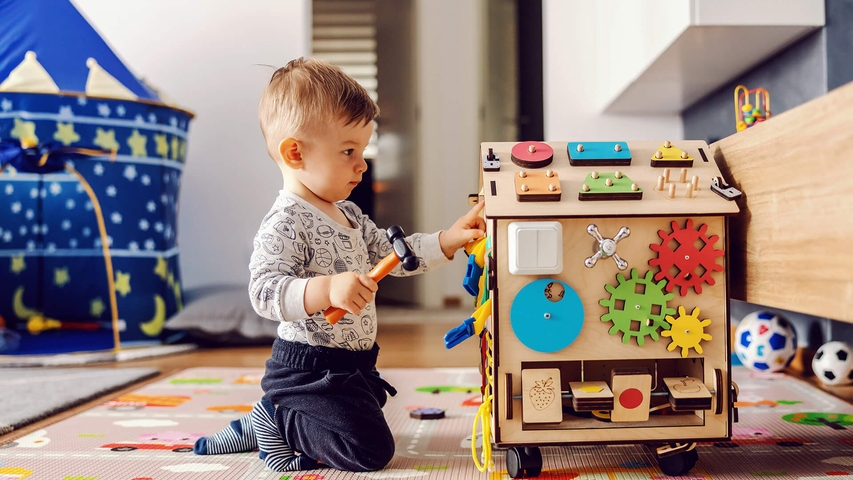 Junge im Kindergartenalter spielt mit Holzspielzeug