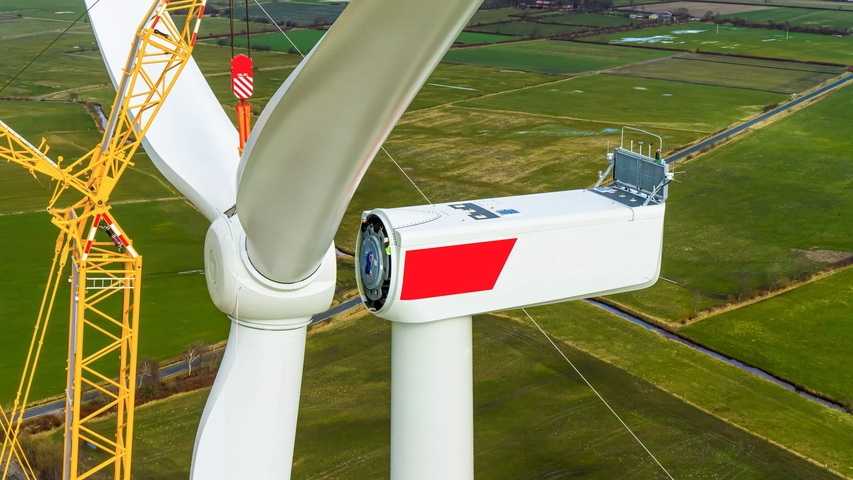 Luftaufnahme einer Windkraftanlage bei der Installationvder Rotorblätter
