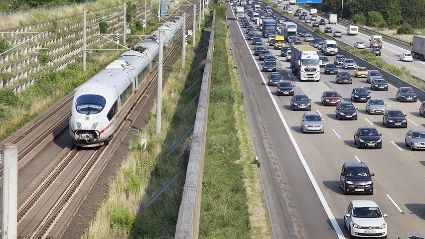 Stau auf der Autobahn und fahrender Zug