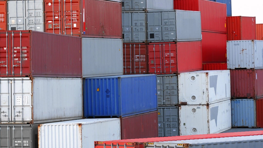 Rote, blaue und weiße Container an einem Verladeplatz