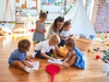 Kindergärtnerin liest Kindern ein Buch vor 
