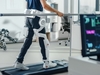 Patient mit Verletzungen geht auf dem Laufband mit fortschrittlichen Roboter-Exoskelett-Beinen