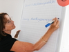 Eine Beraterin wie sie etwas auf eine Flipchart schreibt 