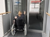 Mitarbeiterin im Rollstuhl öffnet Haustür