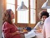 Schwangere Frau sitzt im Business-Meeting