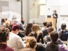 Eine Person hält einen Vortrag vor Studierenden