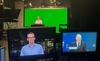 Zwei Aufnahmebildschirme einer TV-Aufzeichnung im Vordergrund, im Hintergrund Sitze Herr Böhmer vor einem Green Screen