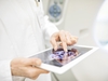 Arzt oder Forscher in einem weißen Kittel, der ein Tablet in den Händen hält