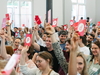 Personen zeigen Postkarten mit dem Prognos-Logo